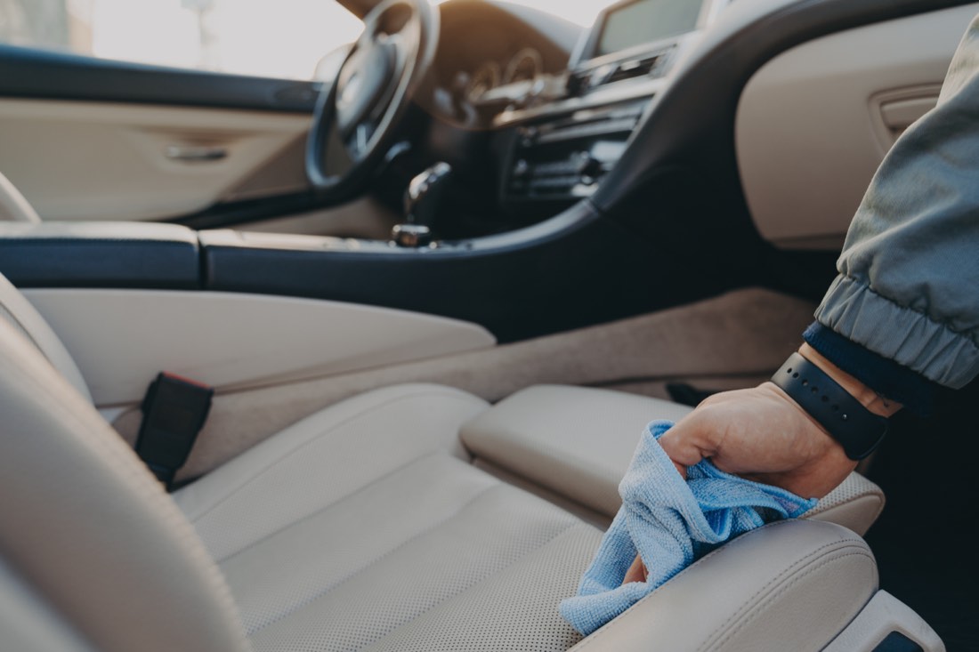 Detailer wiping down a car interior